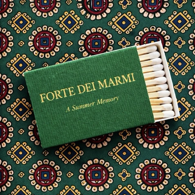 A green Forte dei Marmi matchbox on a patterned cloth