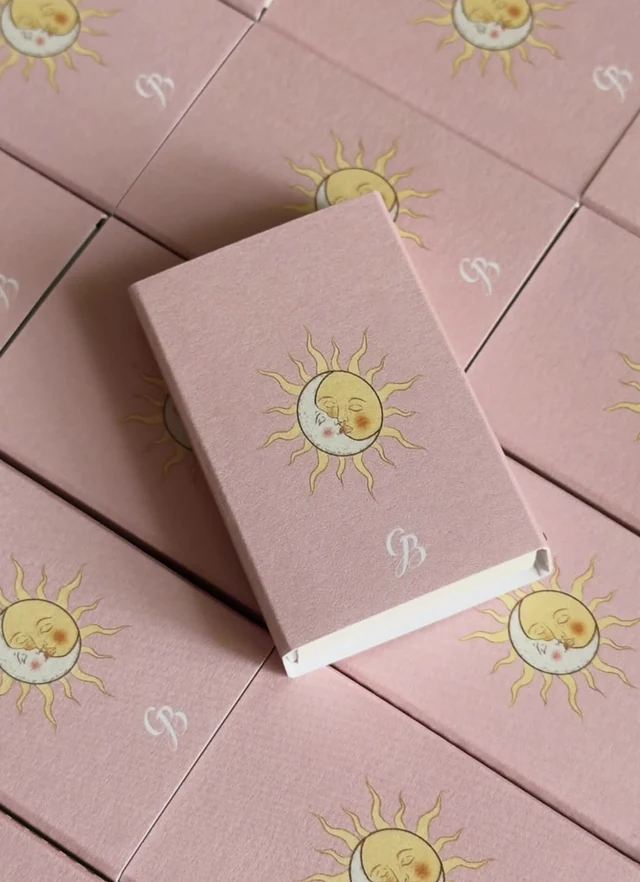 Pink matchboxes printed with a golden sun and moon