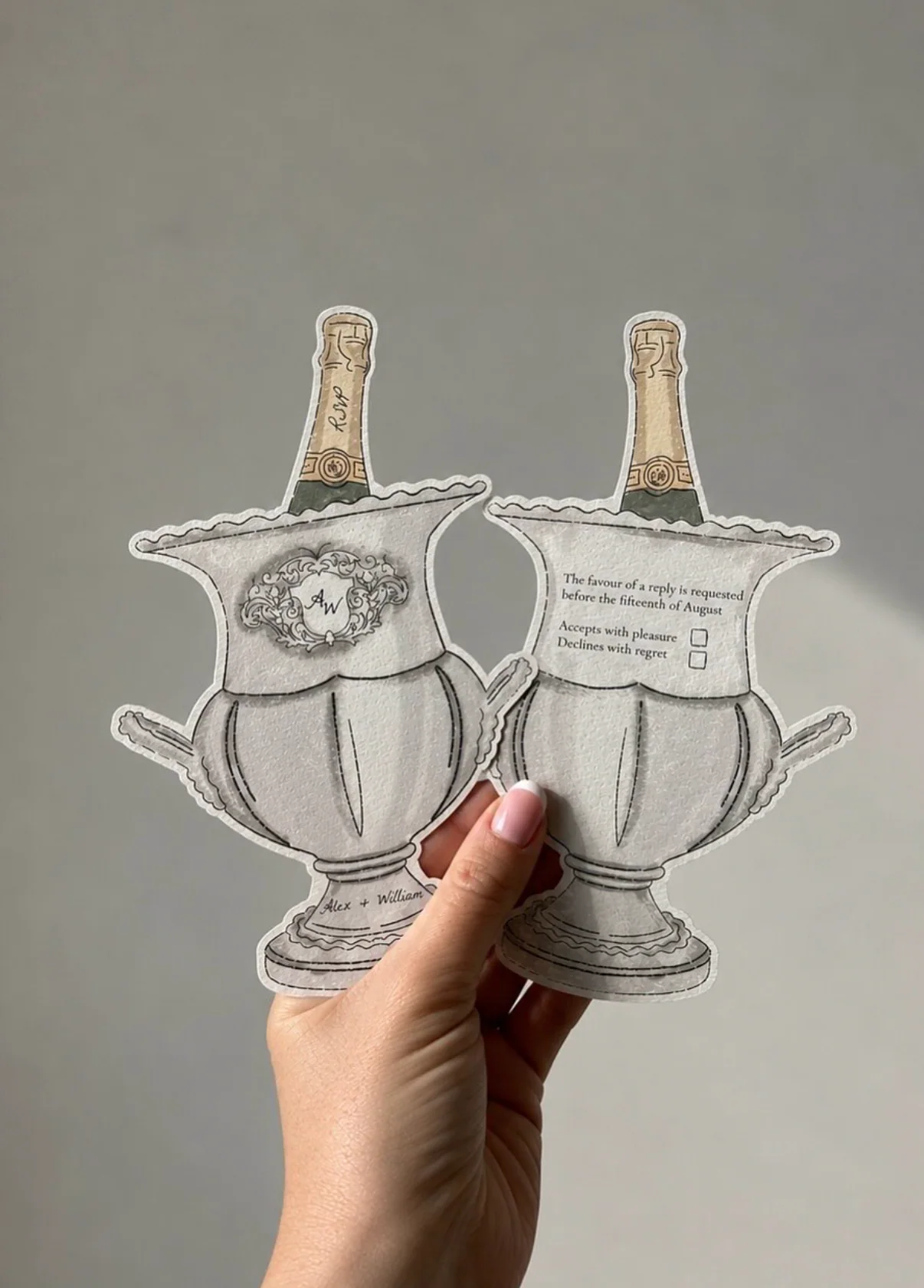 Champagne cooler shaped RSVP cards held in hand